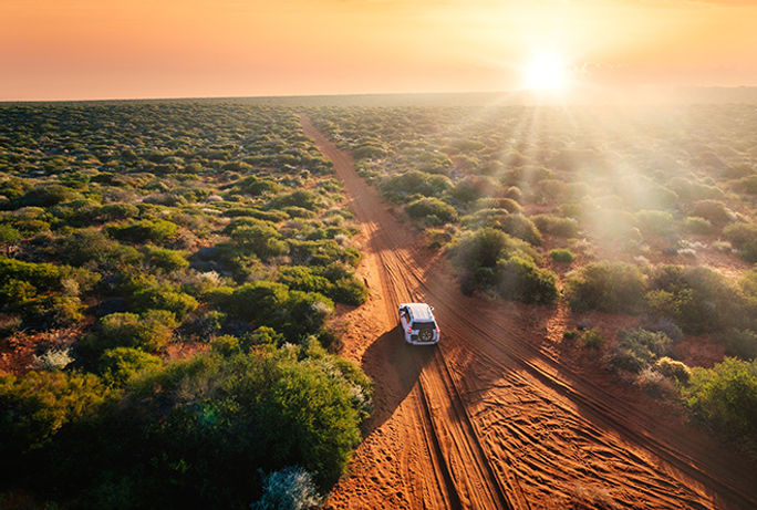 Driving through the Australian outback at sunset. Driving through the Australian outback at sunset.