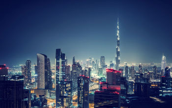 Beautiful Dubai cityscape, bird's eye view on a night urban scene, modern city panoramic landscape, United Arab Emirates (photo via Anna_Om / iStock / Getty Images Plus)